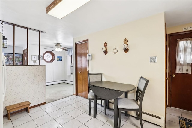 tiled dining space with ceiling fan and baseboard heating