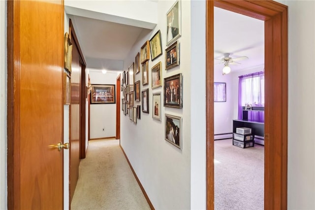 hall with light carpet and a baseboard heating unit