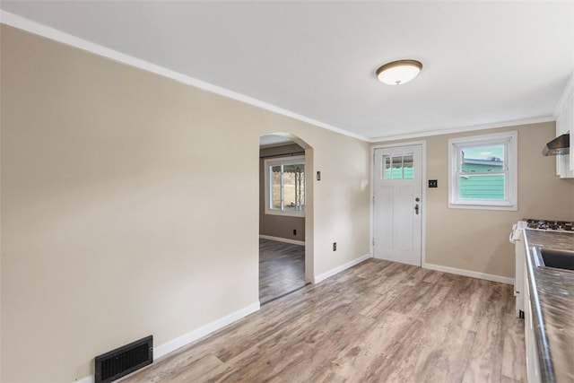 entryway featuring crown molding and light hardwood / wood-style flooring