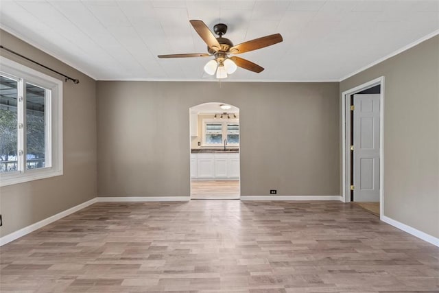 unfurnished room featuring ceiling fan, sink, a wealth of natural light, and light hardwood / wood-style floors