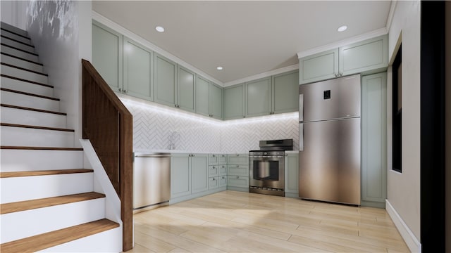 kitchen with tasteful backsplash, appliances with stainless steel finishes, and light hardwood / wood-style flooring