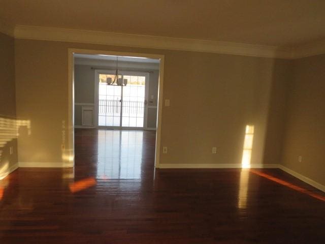 unfurnished room with dark wood-type flooring and ornamental molding