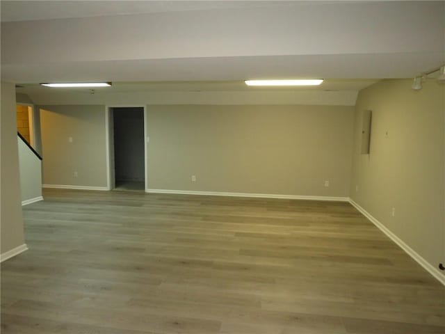 basement featuring hardwood / wood-style flooring and electric panel