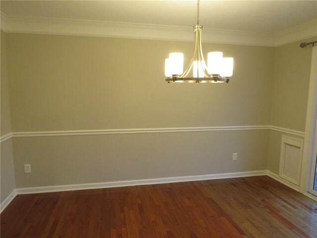 spare room with ornamental molding, dark hardwood / wood-style floors, and an inviting chandelier