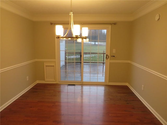 unfurnished dining area featuring crown molding, dark wood-type flooring, and an inviting chandelier