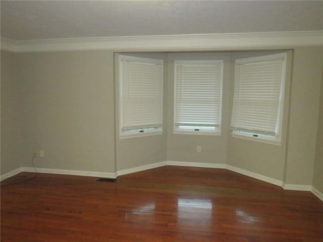 unfurnished room with crown molding and dark hardwood / wood-style flooring