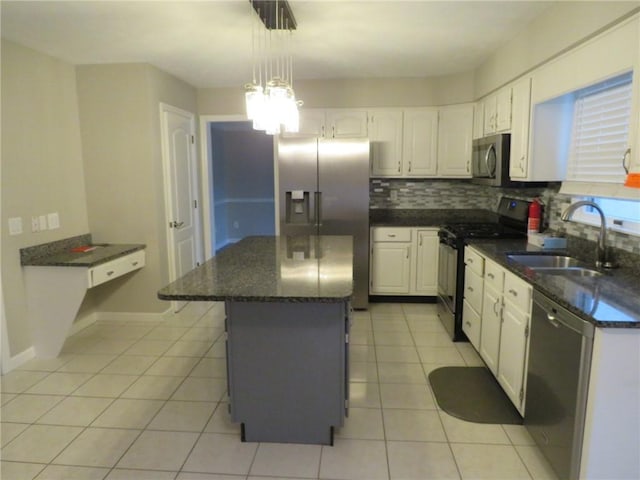 kitchen with sink, white cabinetry, decorative light fixtures, appliances with stainless steel finishes, and a kitchen island