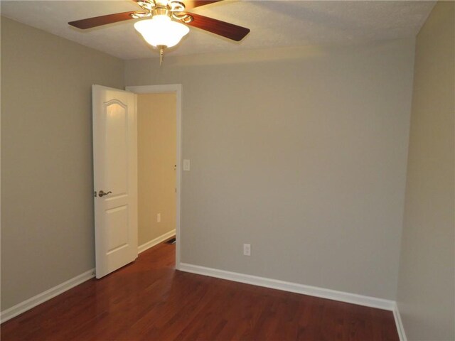 empty room featuring dark hardwood / wood-style floors and ceiling fan