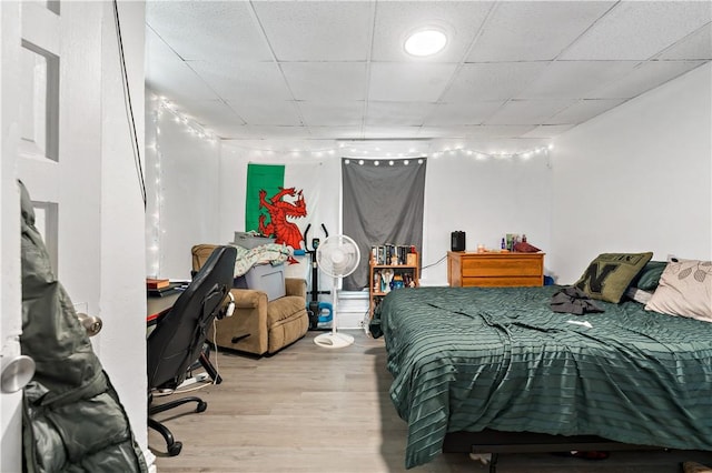 bedroom with light hardwood / wood-style floors and a drop ceiling