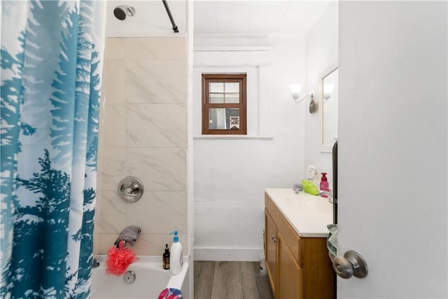 bathroom with hardwood / wood-style flooring, vanity, and shower / bath combo with shower curtain