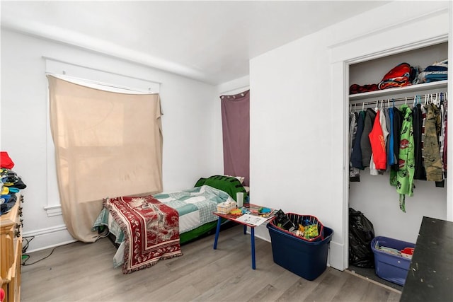 bedroom with light hardwood / wood-style flooring and a closet