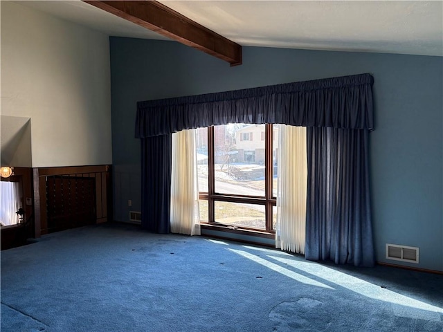 unfurnished living room with lofted ceiling with beams, carpet flooring, and visible vents