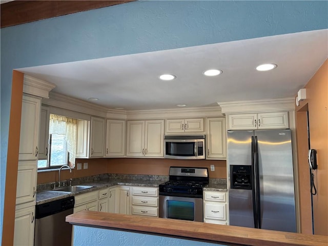 kitchen with wood counters, appliances with stainless steel finishes, a sink, and recessed lighting