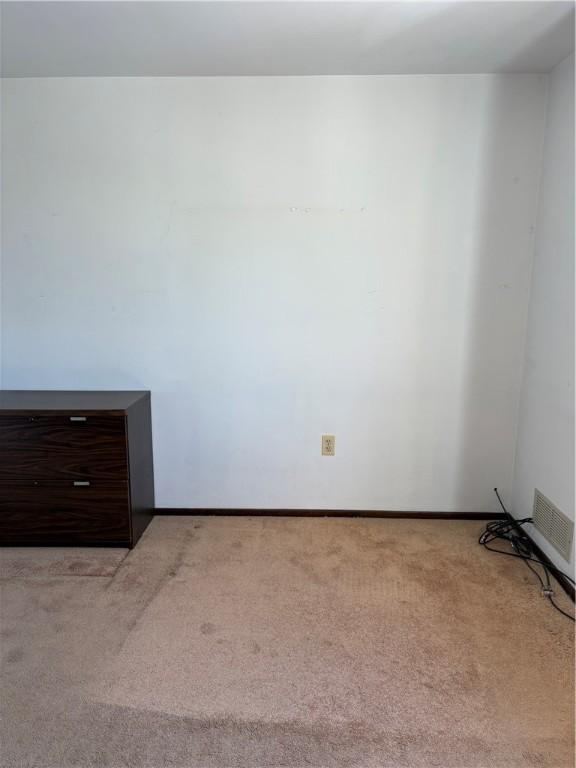 unfurnished room featuring light carpet