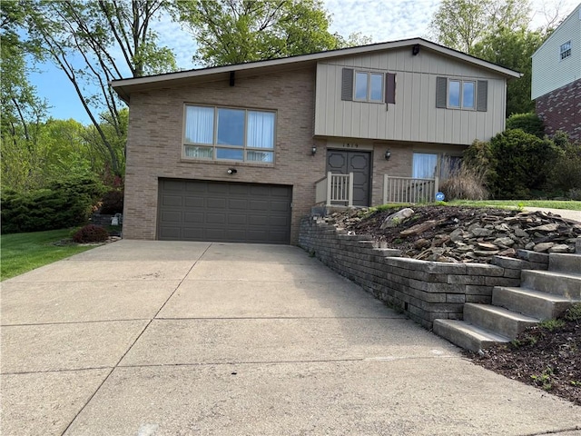 split level home with brick siding, an attached garage, and driveway