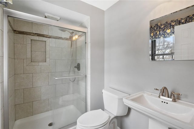 bathroom featuring walk in shower, sink, and toilet