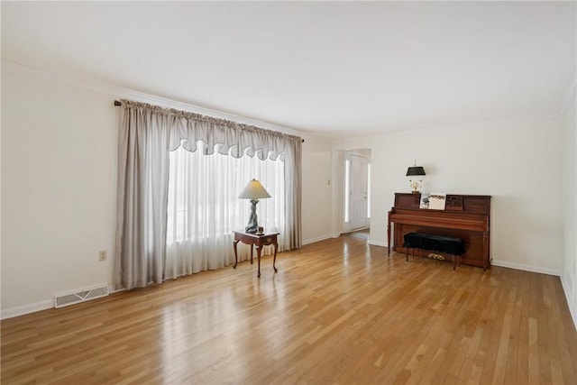 interior space with crown molding and light hardwood / wood-style floors