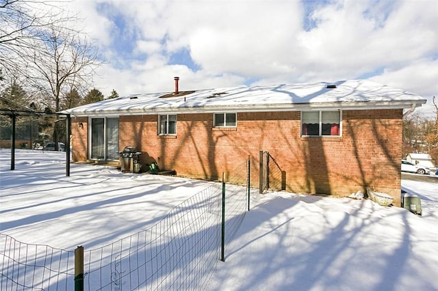 view of snow covered back of property