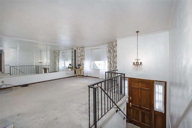 carpeted entrance foyer featuring a notable chandelier and ornamental molding