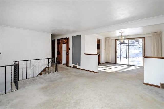 unfurnished room featuring an inviting chandelier, ornamental molding, and carpet floors