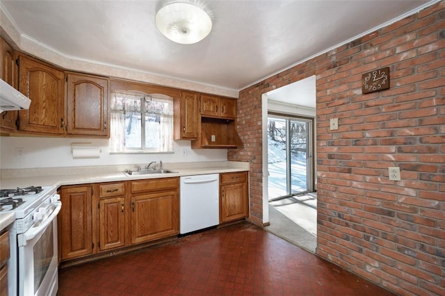 kitchen featuring sink, white appliances, a healthy amount of sunlight, and brick wall