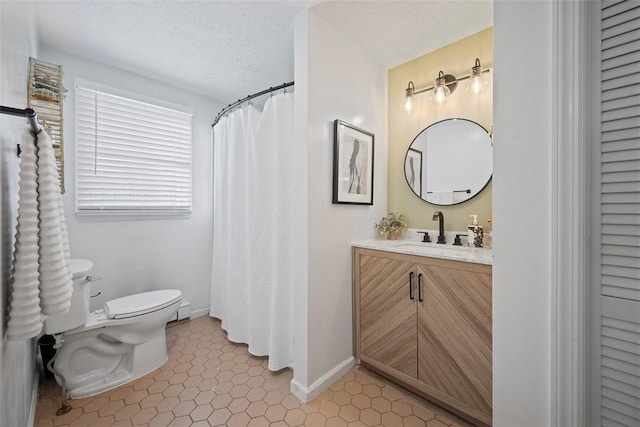 bathroom with vanity, tile patterned floors, a textured ceiling, and toilet