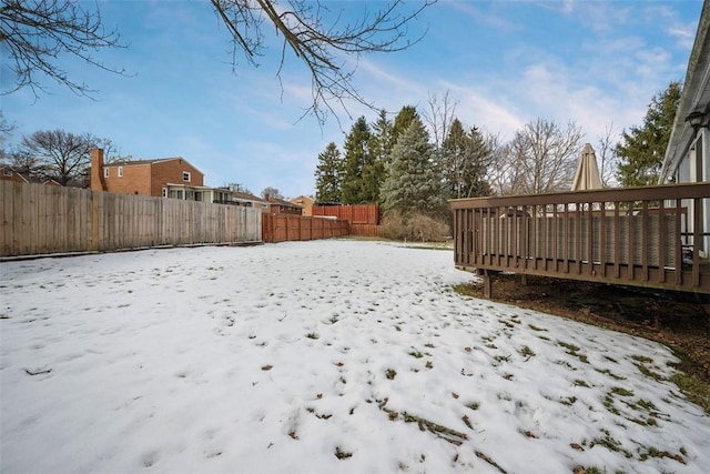 yard layered in snow with a wooden deck