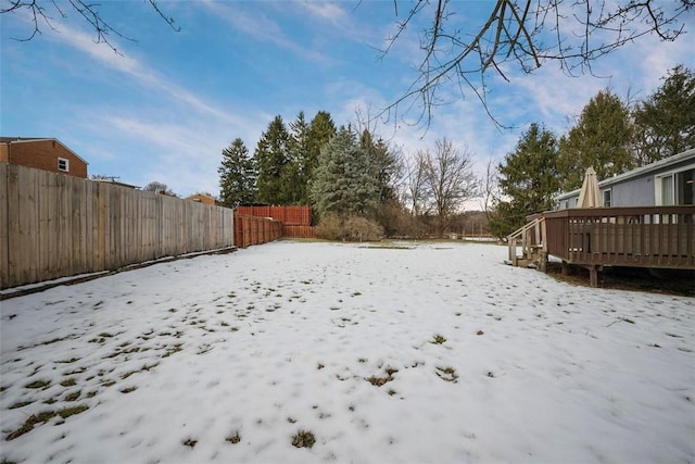 yard covered in snow featuring a deck