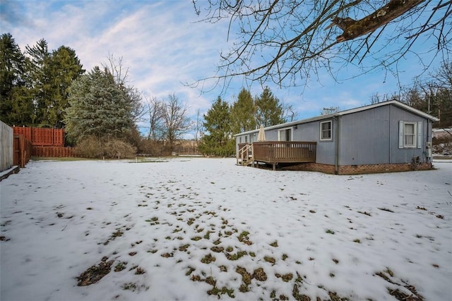 yard covered in snow with a deck