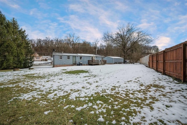 yard layered in snow featuring a wooden deck