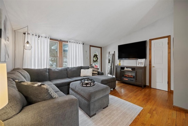 living room with lofted ceiling and light wood-type flooring