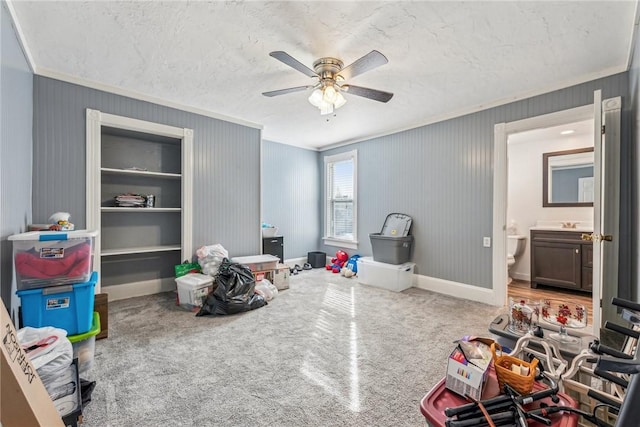 playroom with crown molding, ceiling fan, carpet floors, and a textured ceiling