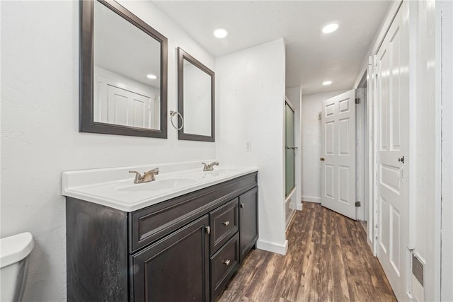 full bathroom with vanity, wood-type flooring, enclosed tub / shower combo, and toilet