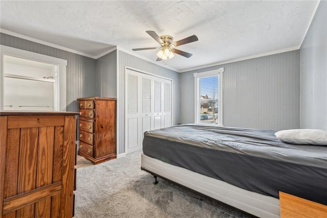 carpeted bedroom with crown molding, a textured ceiling, a closet, and ceiling fan