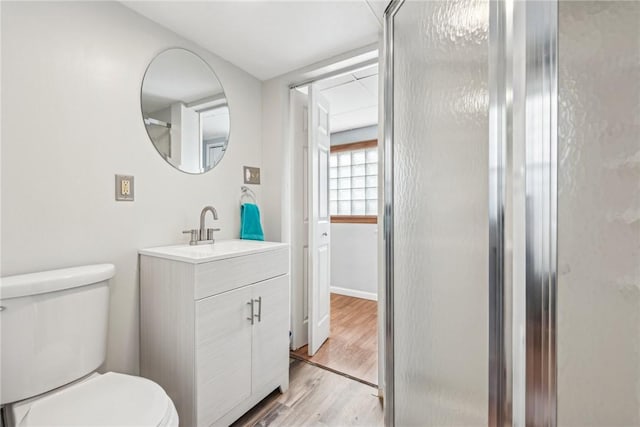 bathroom featuring vanity, hardwood / wood-style flooring, toilet, and walk in shower