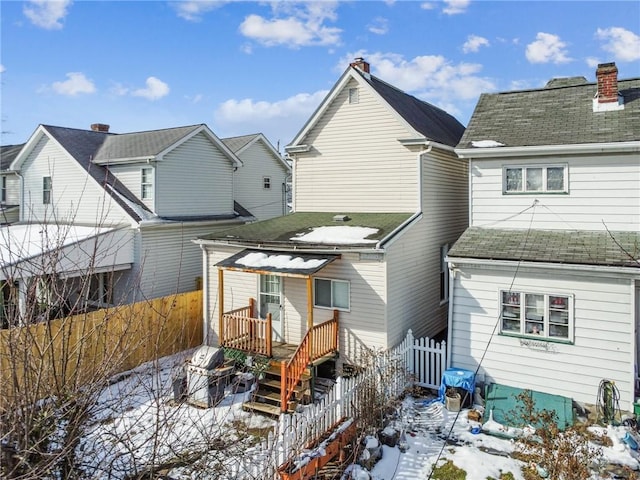 view of snow covered back of property