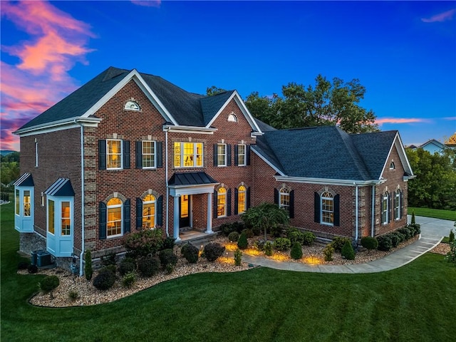 colonial home with central air condition unit and a lawn