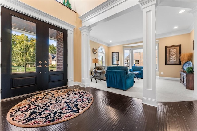 foyer featuring ornate columns, ornamental molding, wood-type flooring, and french doors