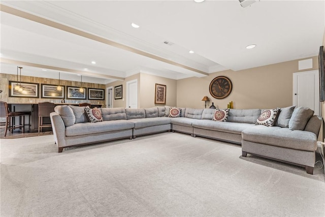 living room featuring light carpet, beam ceiling, crown molding, and bar area