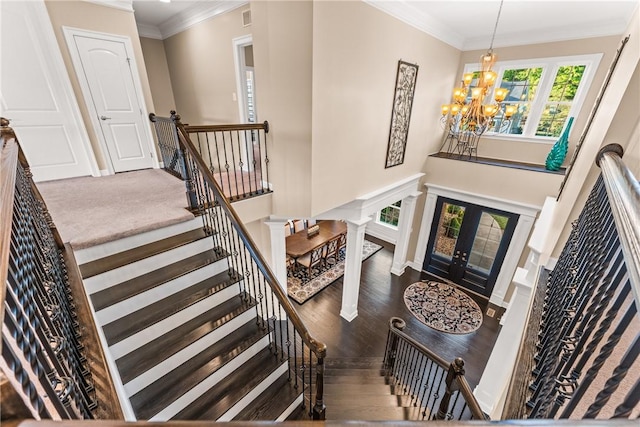 stairs featuring french doors, ornamental molding, hardwood / wood-style floors, and a notable chandelier