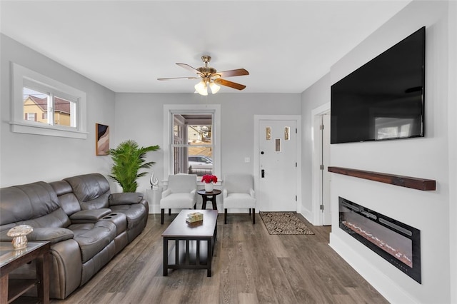 living room with dark wood-type flooring and ceiling fan