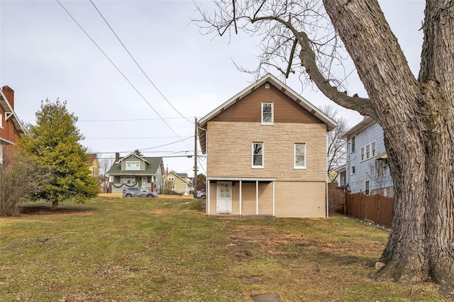 rear view of property featuring a lawn