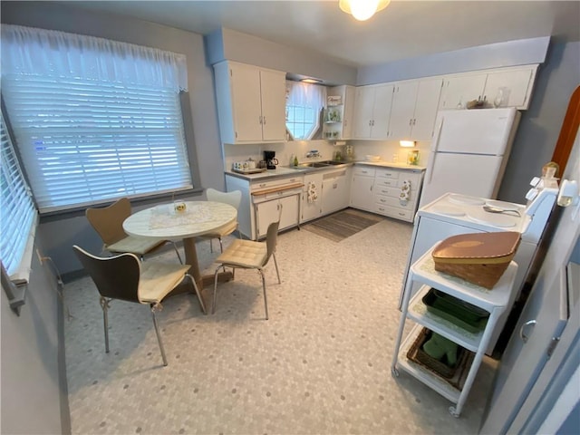 kitchen with white fridge, sink, and white cabinets