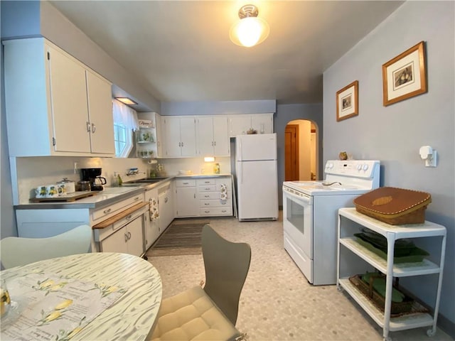 kitchen featuring sink, white cabinets, and white appliances