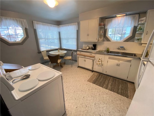 kitchen with white cabinetry, sink, and white range with electric cooktop