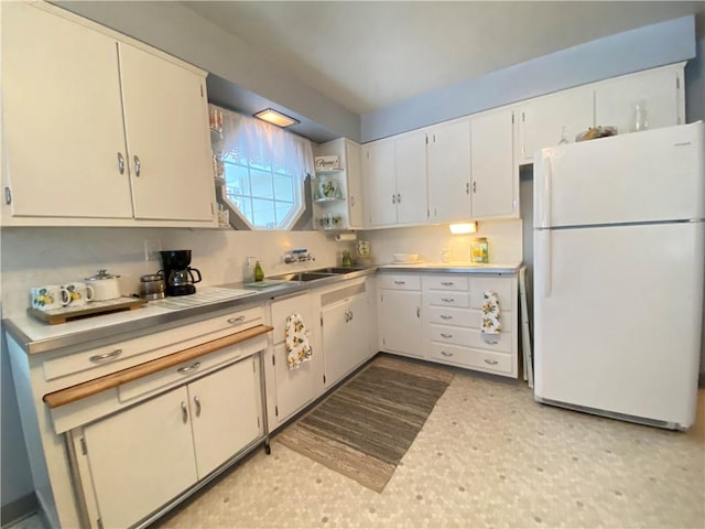 kitchen featuring white cabinetry, sink, and white refrigerator