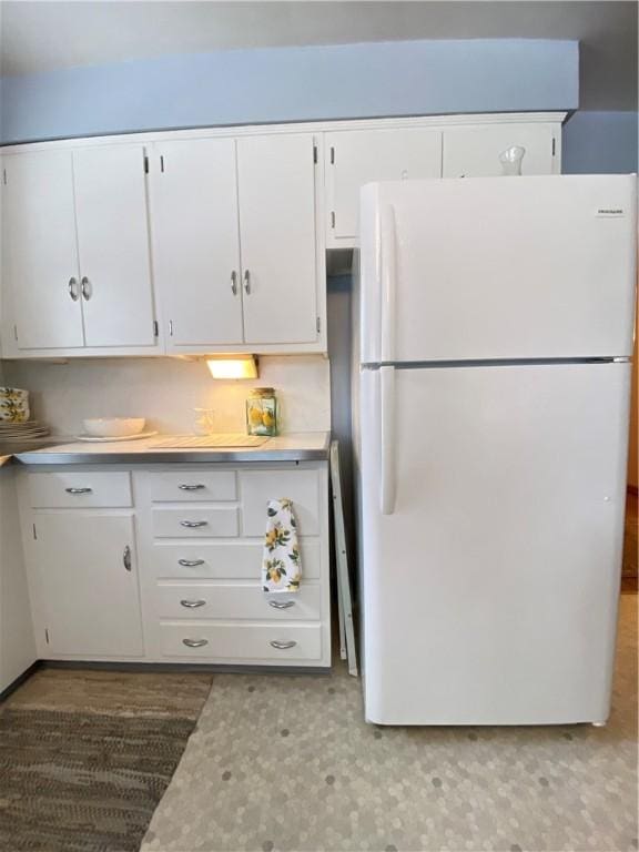 kitchen featuring white cabinets and white fridge