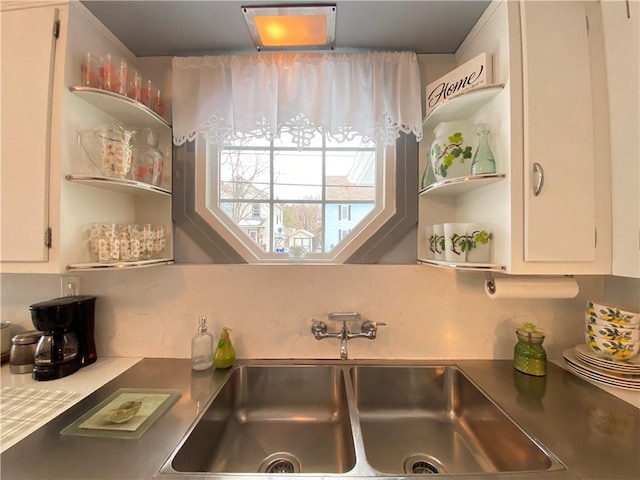 kitchen with white cabinetry, sink, and decorative backsplash