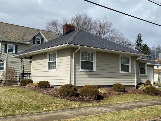 view of property exterior featuring a yard, a chimney, and roof with shingles