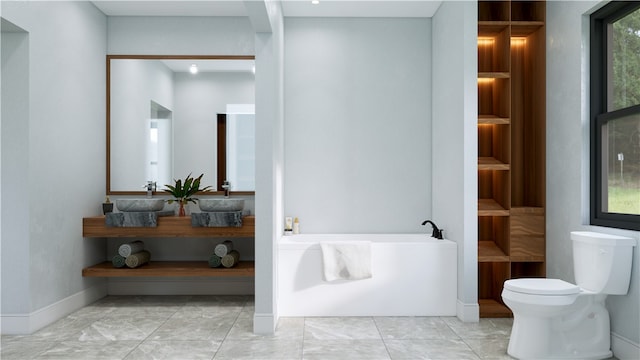 bathroom featuring a washtub, sink, and toilet